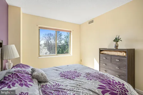 a bedroom with a bed and a painting on the wall