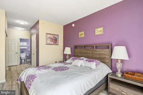 a bedroom with a bed and a painting on the wall