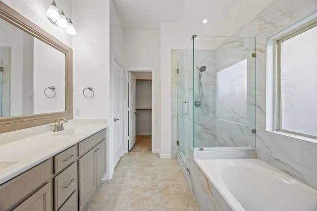 a spacious bathroom with a shower sink and mirror with bathtub