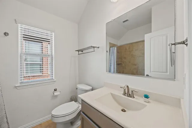 a bathroom with a sink vanity mirror and toilet