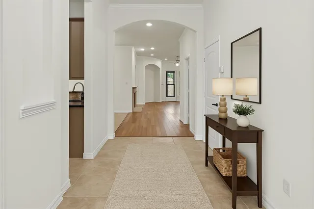 a view of a hallway with wooden floor and a bathroom