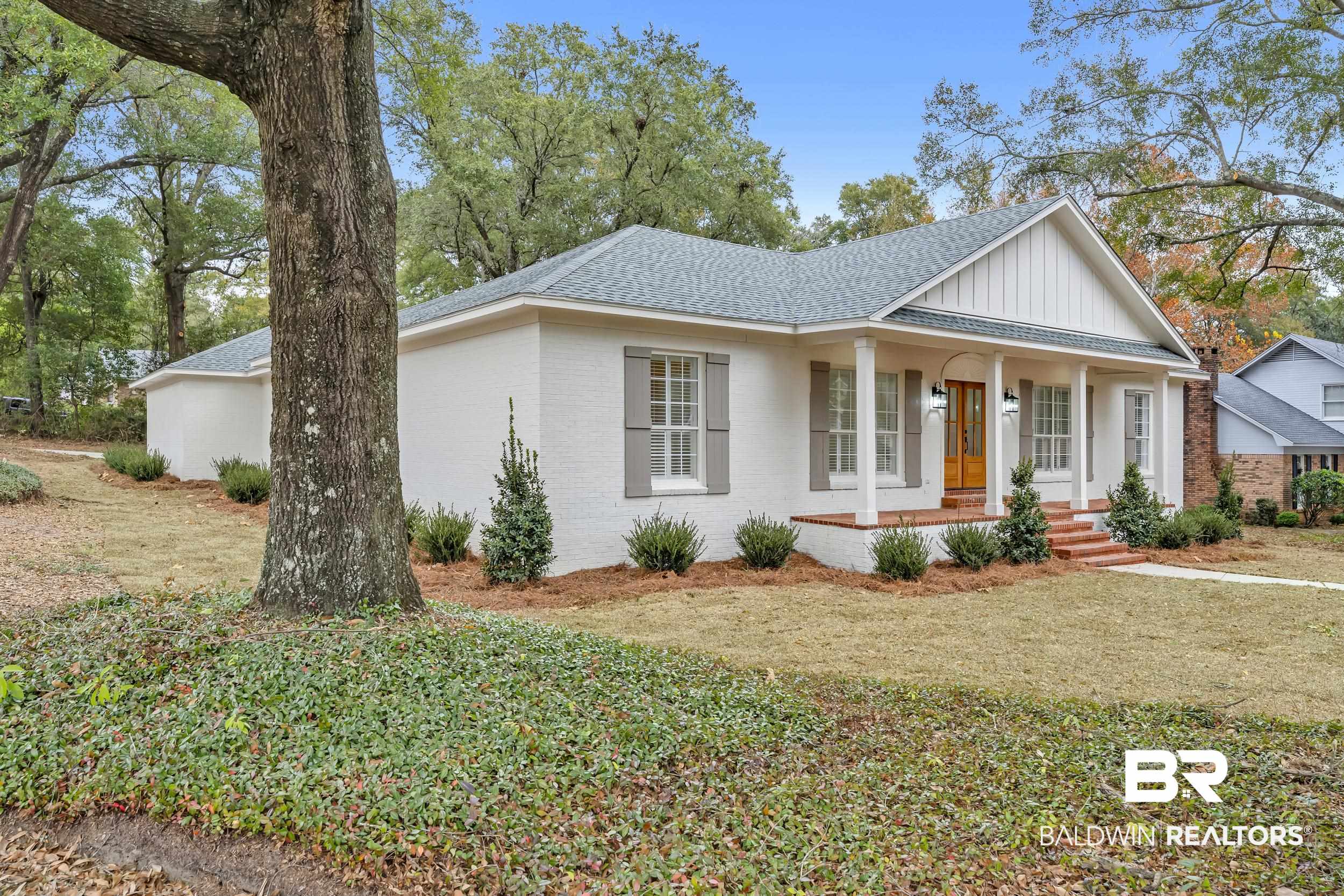 4924 Brooke Court Mobile, AL 36618 - Photo 2 of 34 View of front facade with board and batten siding, a shingled roof, covered porch, brick siding, and a front yard