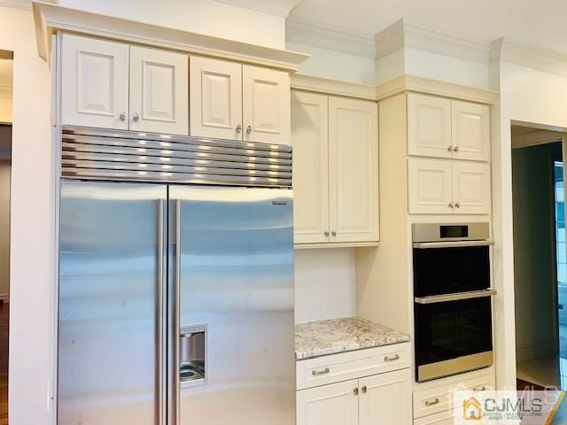 17 Clive Hills Road Edison, NJ 08820 - Photo 8 of 23 a kitchen with white cabinets and black appliances