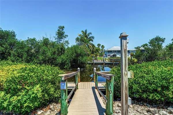a view of a swimming pool and lounge chair in back yard of the house