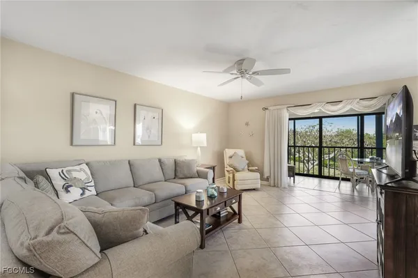 a living room with furniture and a floor to ceiling window
