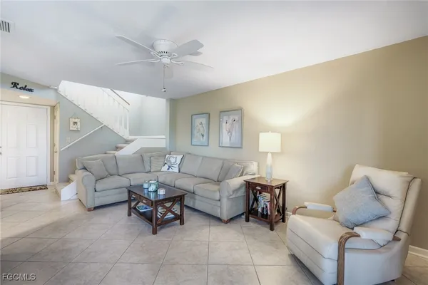 a living room with furniture and a ceiling fan