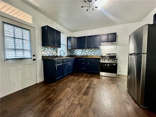 a kitchen with stainless steel appliances granite countertop a stove refrigerator and cabinets