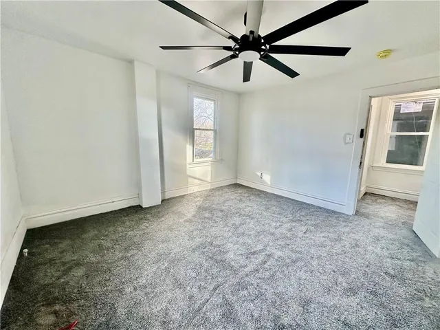 an empty room with chandelier fan