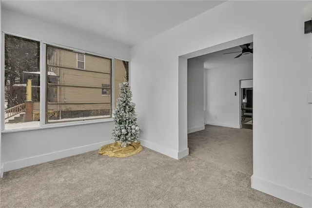 a living room with furniture and a ceiling fan