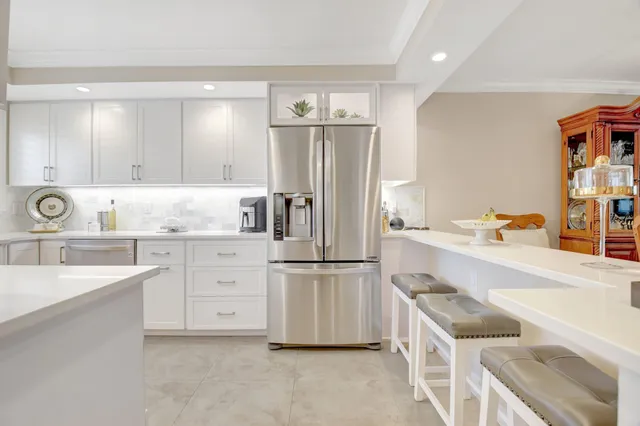 a kitchen with granite countertop a refrigerator stove and sink