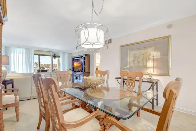 a dining room with furniture a chandelier and wooden floor