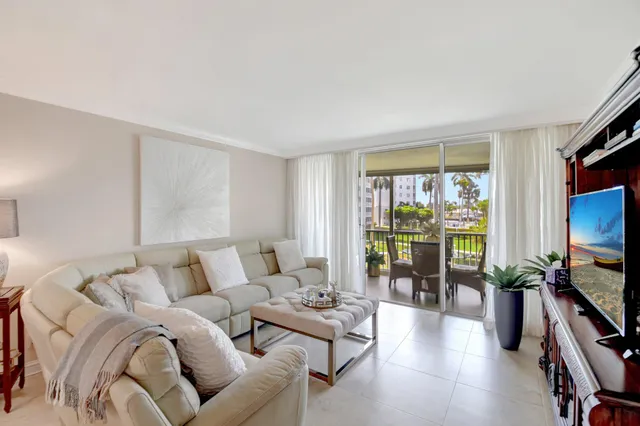 a living room with furniture a flat screen tv and a large window
