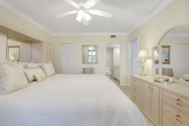 a spacious bedroom with a large bed and a chandelier