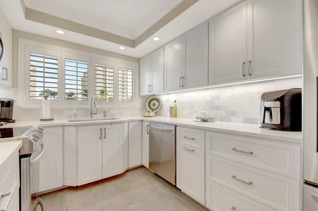 a kitchen with white cabinets and sink