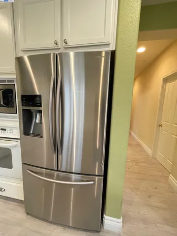 a view of a refrigerator in kitchen and wooden floor