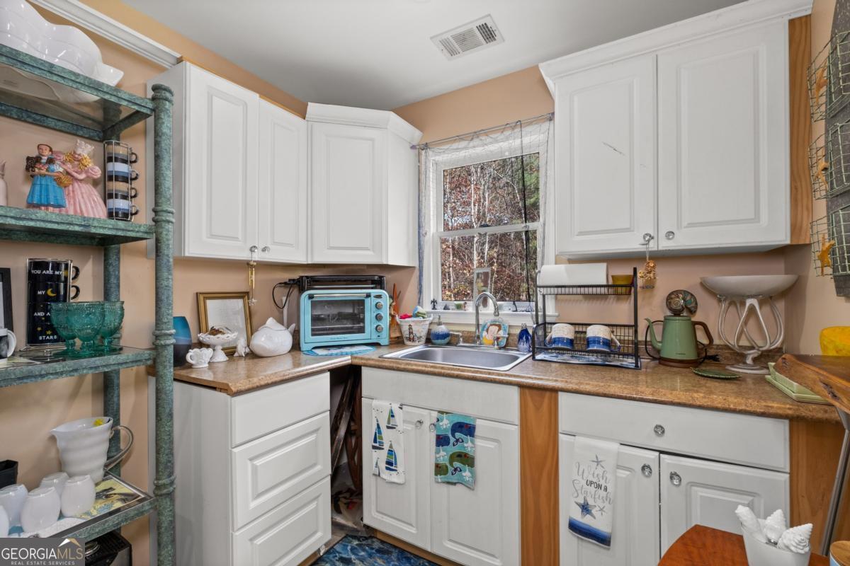 1045 Fincher Road Canton, GA 30114 - Photo 49 of 69 a kitchen with stainless steel appliances granite countertop a stove a sink a refrigerator and white cabinets