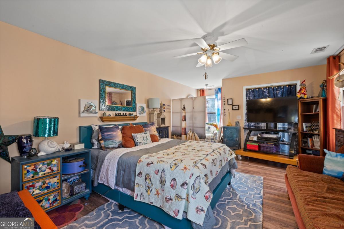 1045 Fincher Road Canton, GA 30114 - Photo 52 of 69 a bedroom with a bed a flat screen tv and a chandelier