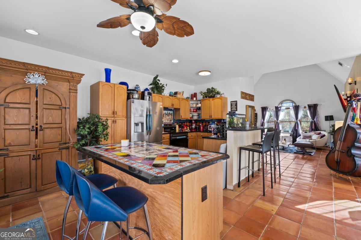 1045 Fincher Road Canton, GA 30114 - Photo 6 of 69 a open dining room with stainless steel appliances kitchen island granite countertop a table chairs and a refrigerator