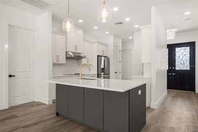 a kitchen with stainless steel appliances granite countertop a sink and dishwasher with wooden floor