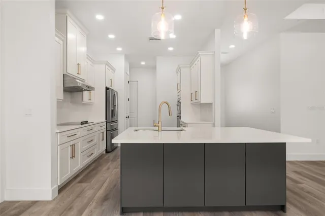 a kitchen with kitchen island a sink and wooden floor