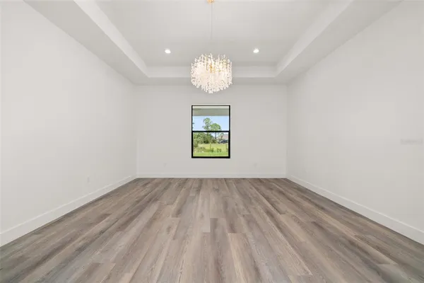 an empty room with wooden floor and fan