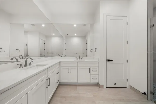 a spacious bathroom with a granite countertop sink a toilet and a mirror