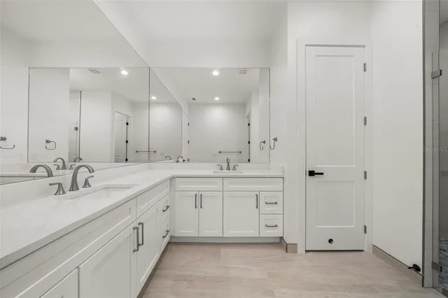 a spacious bathroom with a granite countertop sink a toilet and a mirror