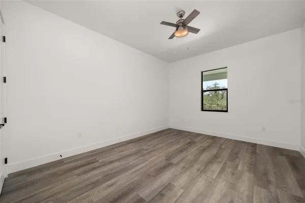an empty room with a window and ceiling fan