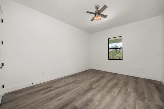 an empty room with a window and ceiling fan