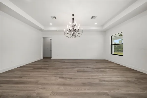 a view of a room with kitchen island stainless steel appliances sink and wooden floor