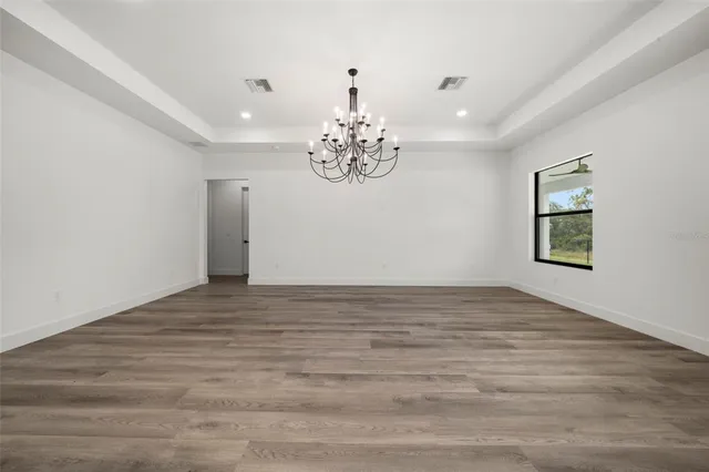 a view of a room with kitchen island stainless steel appliances sink and wooden floor