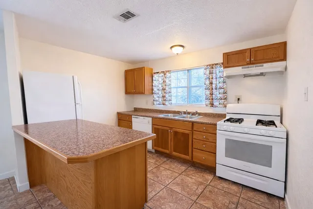 a kitchen with a stove sink and cabinets
