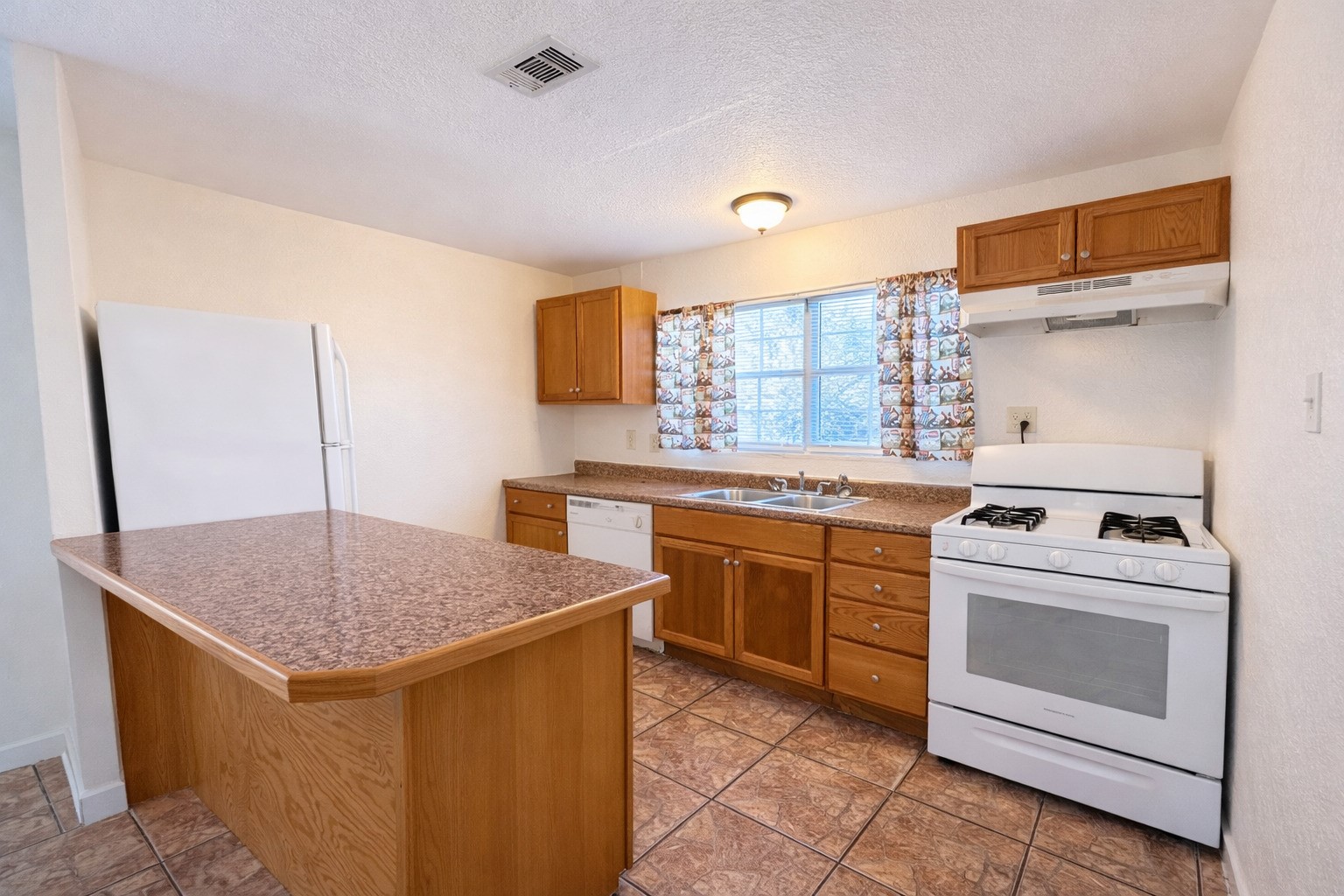 612 Harvey Street Clute, TX 77531 - Photo 2 of 12 a kitchen with a stove sink and cabinets