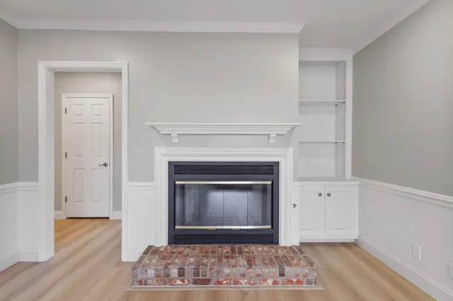 a view of a livingroom with wooden floor and a fireplace