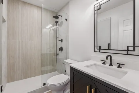 a bathroom with a sink toilet vanity and shower