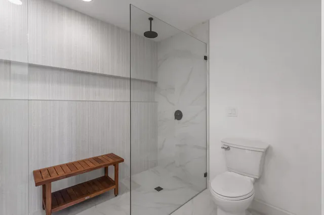 a bathroom with a shower a toilet and a sink