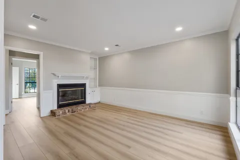 a view of empty room with wooden floor and fireplace