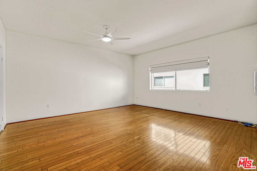 5534 Sylmar Avenue, Unit 5 Sherman Oaks, CA 91401 - Photo 20 of 33 a view of an empty room with wooden floor and a window