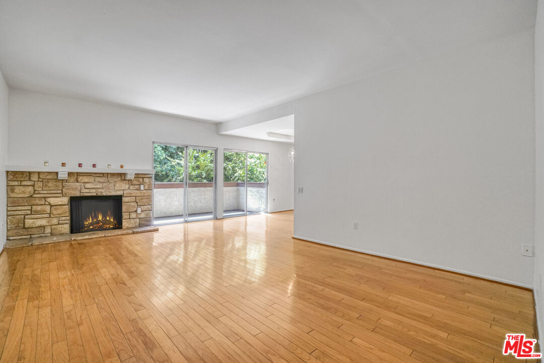 5534 Sylmar Avenue, Unit 5 Sherman Oaks, CA 91401 - Photo 2 of 33 a view of empty room with wooden floor and fireplace