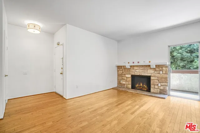 a view of empty room with a fireplace and wooden floor