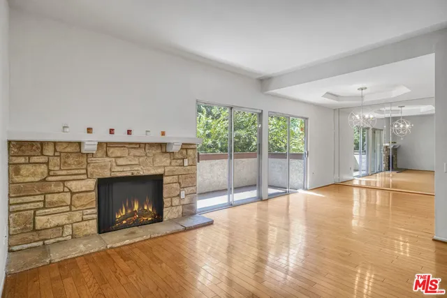 a view of empty room with wooden floor and fireplace