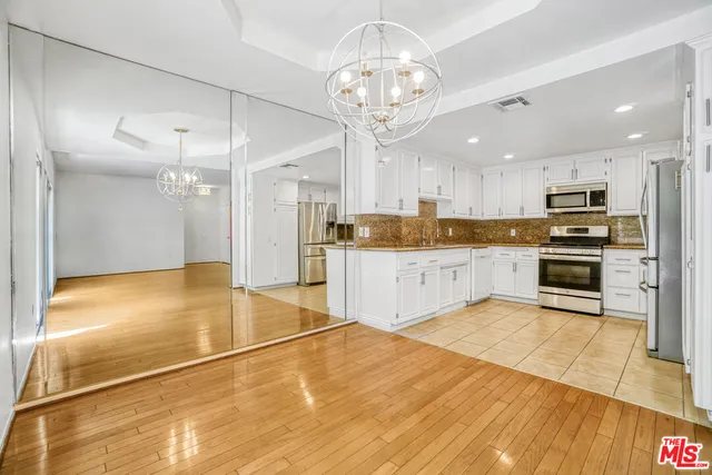 a large kitchen with cabinets and wooden floor