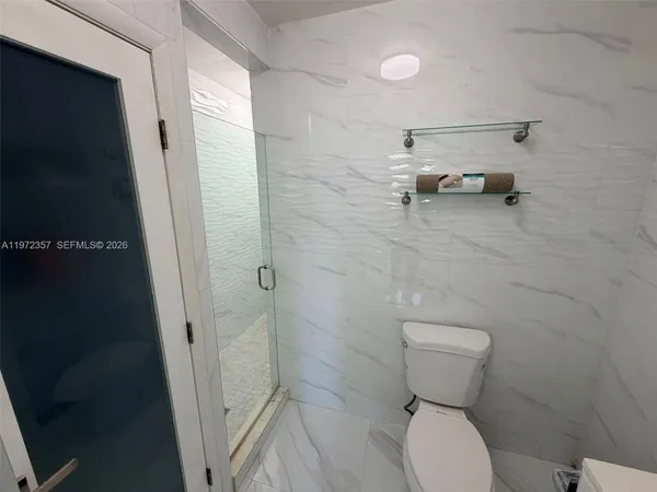 a bathroom with a toilet and a shower