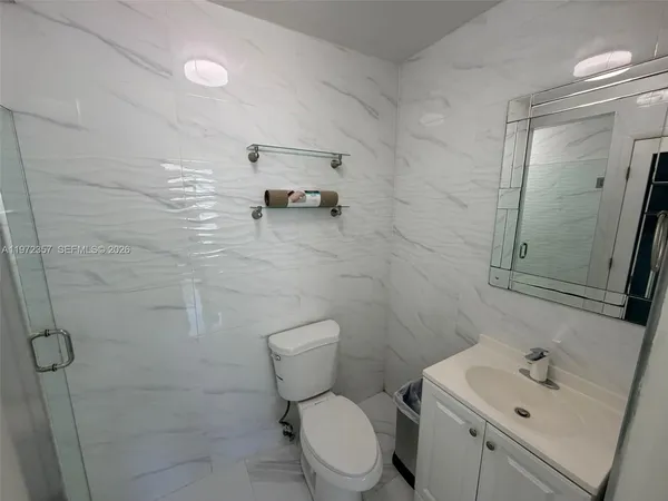 a bathroom with a toilet sink and mirror