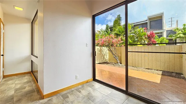a view of a hallway with wooden floor and a potted plant
