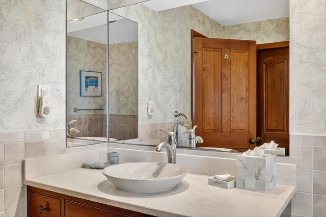 a bathroom with a granite countertop sink and a mirror
