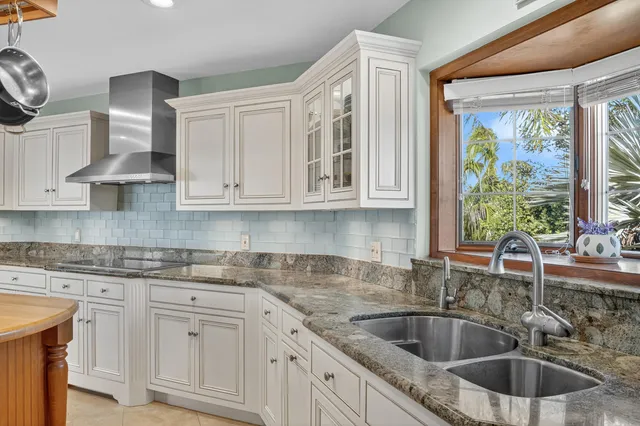 a kitchen with stainless steel appliances granite countertop a sink a stove and cabinets