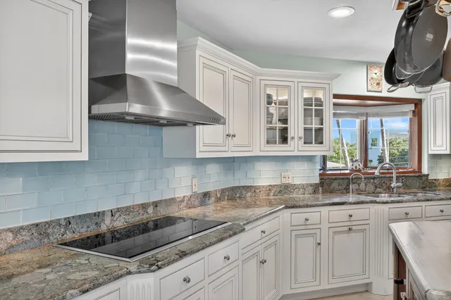 a kitchen with granite countertop a sink stainless steel appliances and cabinets