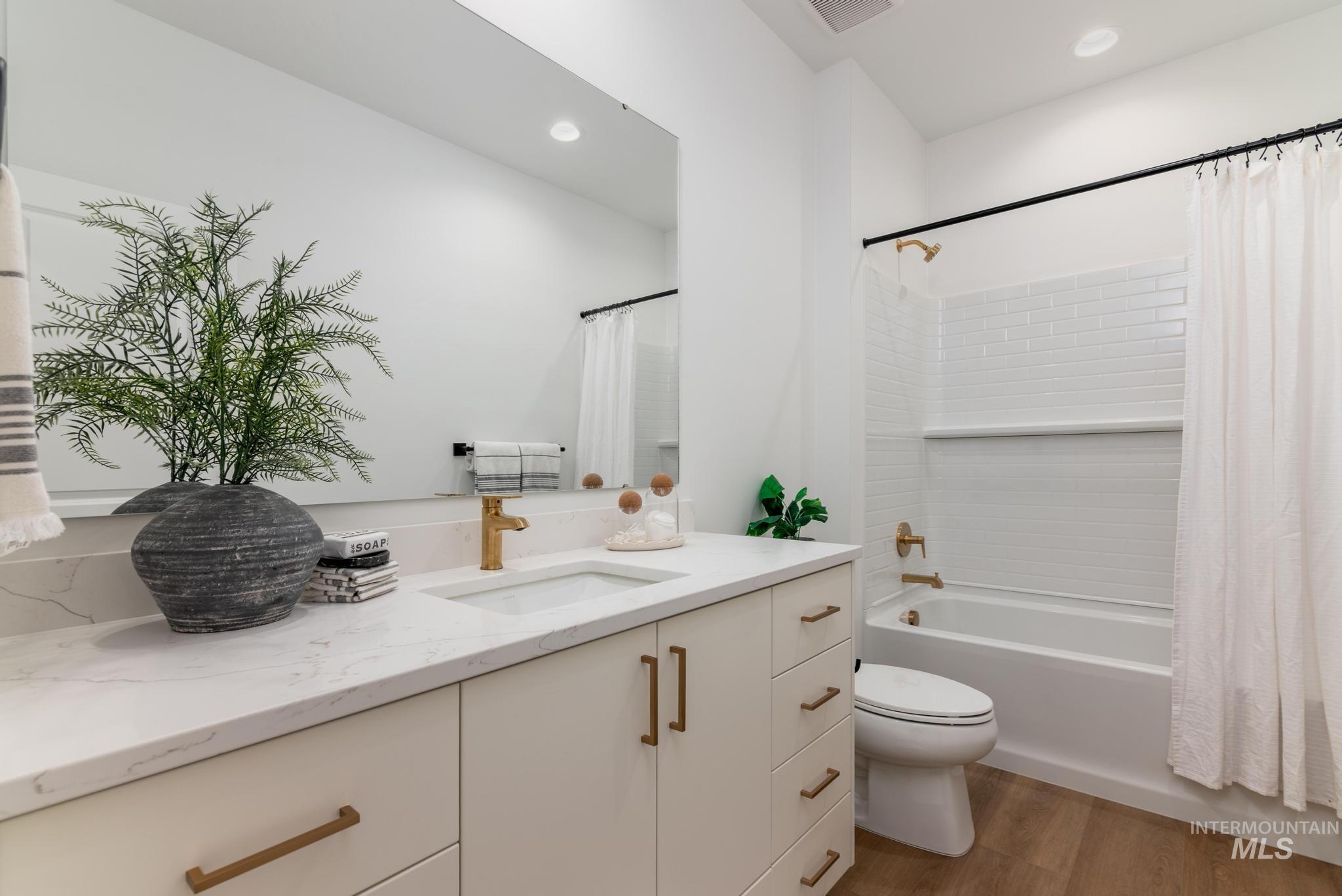 14703 Serenity Pt Street Caldwell, ID 83607 - Photo 26 of 45 Bathroom featuring a single vanity with stone-finish countertop, undermount sink, and brass-tone hardware
