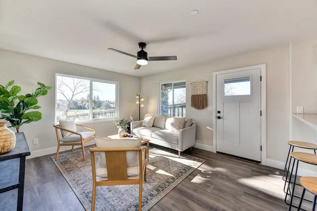 a living room with stainless steel appliances kitchen island granite countertop furniture and a rug